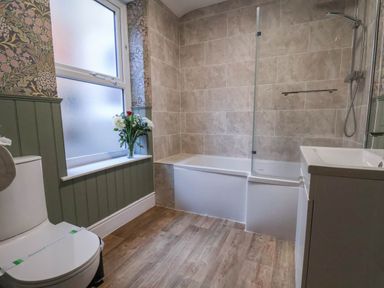 A bathroom with a bathtub and a toilet at Lansdowne Grange in Bridlington
