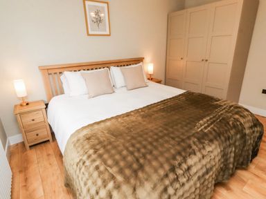 A bedroom with a bed and bedside table at Hedley Dene Cottage in Longhorsley