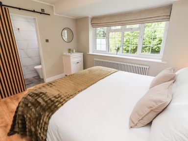 A bedroom with a bed and window at Hedley Dene Cottage in Longhorsley