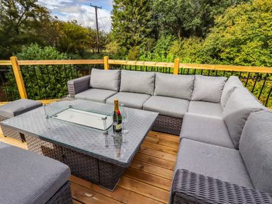 An outdoor seating area with a sofa and a coffee table at Hedley Dene Cottage Longhorsley