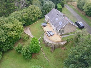 An outdoor area with a house and deck at Hedley Dene Cottage in Longhorsley