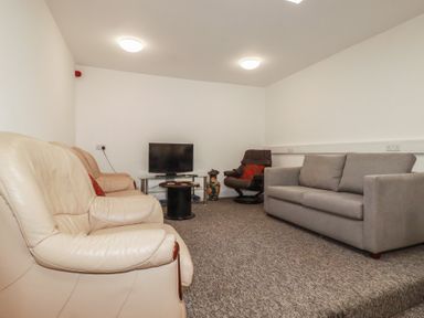 A living room with a sofa and television at Newseal House