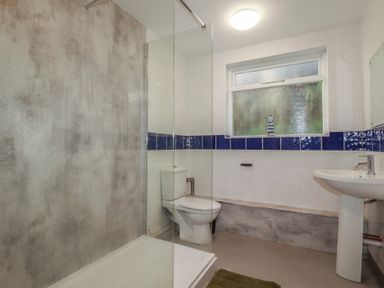 A bathroom with a shower, toilet, and sink at Newseal House 