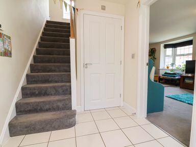 A hallway with stairs and a door at Manning's View Barnstaple