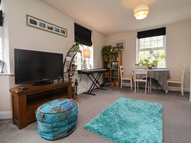 A living room with a television and a dining table at Manning's View in Barnstaple