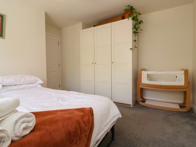 A bedroom with a bed and baby crib at Manning's View in Barnstaple