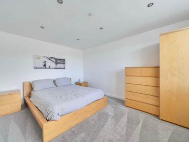 A bedroom with a bed and dresser at The Old Barn in Abergele