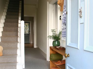 A hallway with stairs and a shelf at Beautiful 6Bed Sleeps 12 Stunning Views in Lynton