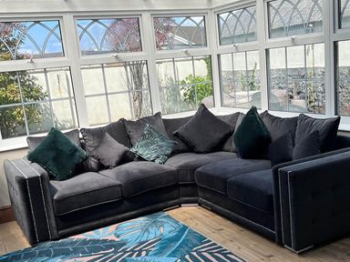 A conservatory with a sofa and windows at Build your memories hot tub garden sleeps 14 in Nottage