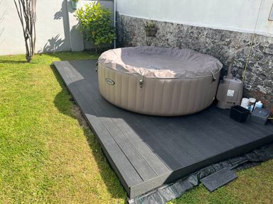 A hot tub with a plastic cover on decking in the garden at Build your memories hot tub garden sleeps 14 Nottage