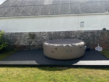A hot tub on a wooden deck surrounded by grass at Build your memories hot tub garden sleeps 14 Nottage