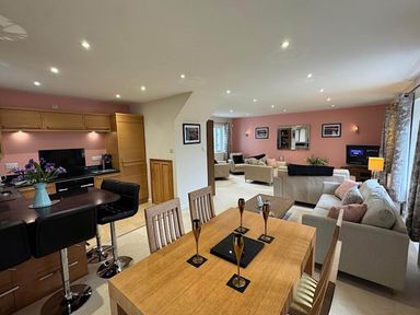 A dining area and living room with furniture at River Tamar Couples Retreat Dog Friendly in Newbridge