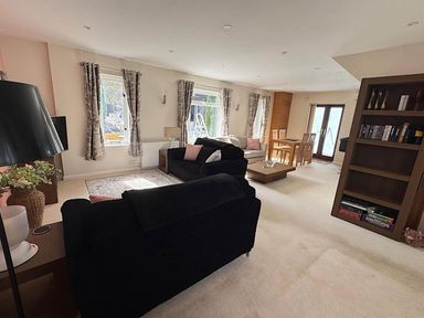 A living room with a sofa and dining area at River Tamar Couples Retreat Dog Friendly in Newbridge