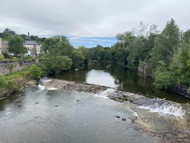 A river with a waterfall and trees at Blairgowrie Luxury 3 Bed Lodge with Hot Tub Blairgowrie