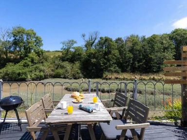 An outdoor seating area with a table and chairs at 2 Bedrooms overlooking Little Petherick Creek Little Petherick