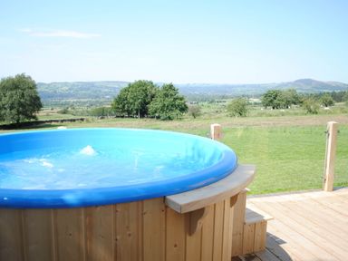 A hot tub on a wooden deck with a view at The Lodge at Brambles Farm Sleeps 4  Hot Tub Leek