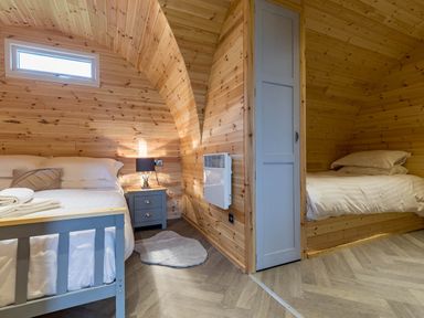 A bedroom with two beds and a bedside table at The Lodge at Brambles Farm Sleeps 4 Hot Tub Leek