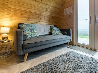 A snug area with a sofa and lamp at The Lodge at Brambles Farm Sleeps 4  Hot Tub in Leek