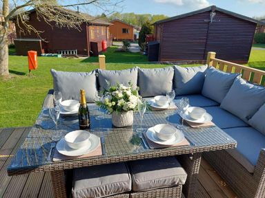 An outdoor dining area with a table set for six at Lakeland Lodge 3Bed 2 Bath Private Patio Carnforth