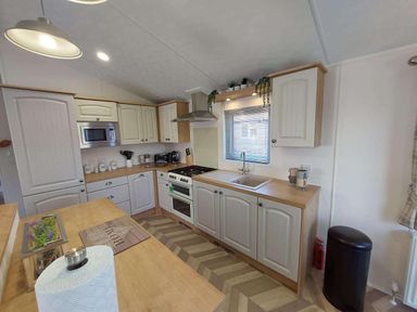 A kitchen with cabinets and appliances at Lakeland Lodge 3Bed 2 Bath Private Patio in Carnforth