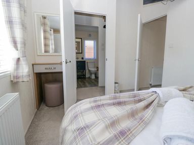 A bedroom with a mirror and doorway leading to a bathroom at Lakeland Lodge 3Bed 2 Bath Private Patio in Carnforth