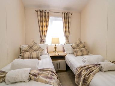 A bedroom with twin beds and a lamp at Lakeland Lodge 3Bed 2 Bath Private Patio in Carnforth