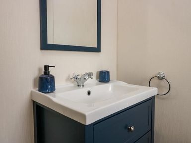 A sink with a mirror and soap dispenser at Lakeland Lodge 3Bed 2 Bath Private Patio in Carnforth