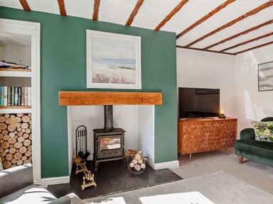 A living room with a fireplace and a television at Cottage Sleeps 5 with Parking and Garden in Carreglefn