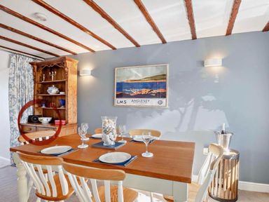 A dining room with a table and chairs at Cottage Sleeps 5 with Parking and Garden in Carreglefn