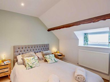 A bedroom with a bed and bedside tables at Cottage Sleeps 5 with Parking and Garden in Carreglefn