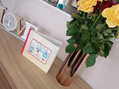 A book and flowers on a table at Seaside Lodge Retreat in Eyemouth