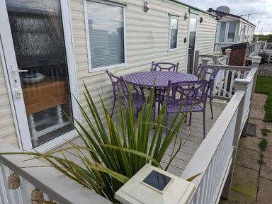 An outdoor seating area with purple furniture at Sandy Paws Dog Friendly Anderby Creek