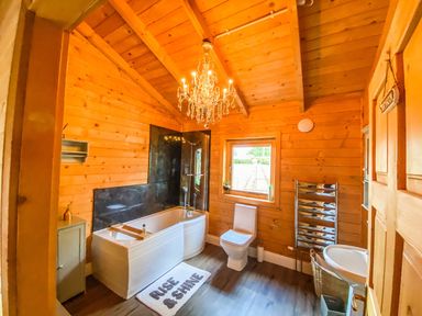 A bathroom with a bathtub, toilet, and sink at The Old Barn in Manchester