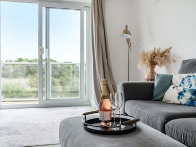 A living room with a champagne bottle and glasses on a tray at Spacious 3 Bed House Sleeps 6 Parking Wifi Newquay