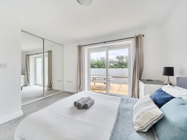 A bedroom with a bed and sliding doors at Spacious 3 Bed House Sleeps 6 Parking Wifi in Newquay