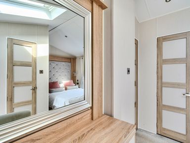 A bedroom with a bed and a mirror at 2Br Lodge Pool Fireplace PetsOK Parking in Goonhavern