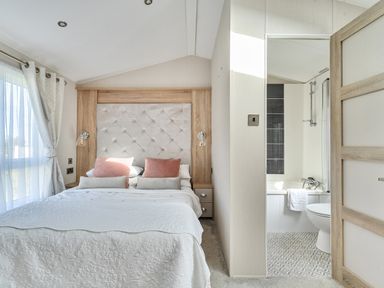 A bedroom with a bed and adjoining bathroom at 2Br Lodge Pool Fireplace PetsOK Parking Goonhavern