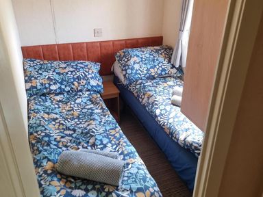 A bedroom with two single beds and a bedside table at Chalet Sleeps 6 swimming pool Thorness Bay