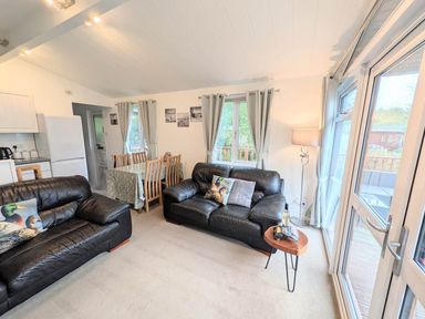 A living room with kitchen area and dining table at Felmoor Park Northumberland Lodge with Hot Tub near Felton