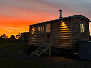 A tiny house with windows and a door at sunset at The Old Barn in Manchester