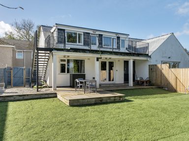An outdoor area featuring a house with a balcony and seating at 1 Bedroom Apartment Sleeps 2 Pets Welcome in Carbis Bay