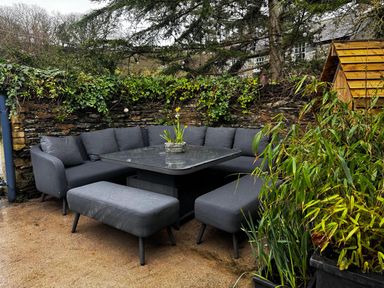 A seating area with a sofa and table in a garden