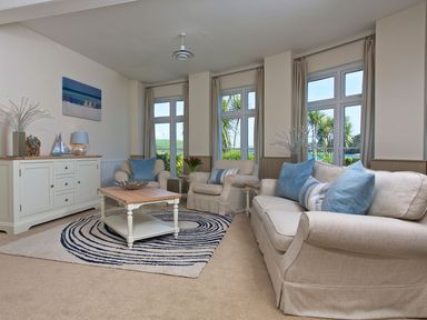 A living room with a sofa and armchair at 4 The Salcombe in Salcombe