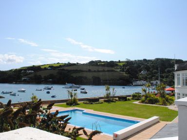 A pool with grass and boats by the water at 4 The Salcombe in Salcombe