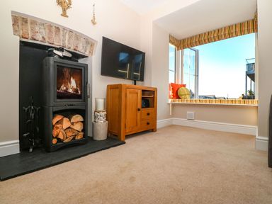 A living room with a fireplace and television at Bryn Tirion - Rhosneigr
