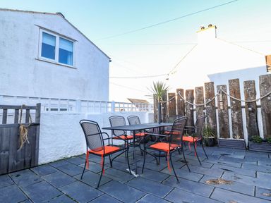 An outdoor dining area with a table and chairs at Bryn Tirion - Rhosneigr