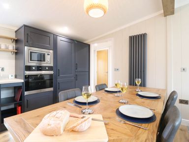 A kitchen with a dining table set for a meal at Cherry Lodge in Battisford near Stowmarket