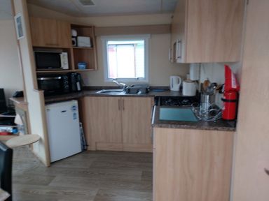 A kitchen with cabinets and appliances at Golden Sands FSB38 in Rhyl