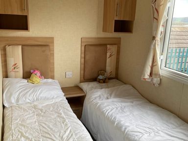 A bedroom with two beds and toys at Golden Sands FSB38 in Rhyl