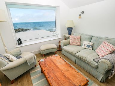 A living room with a large window overlooking the sea at Y Glyn in Borth
